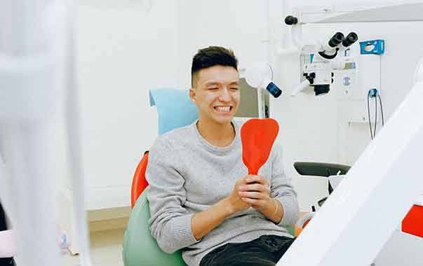 Man in dental chair looking in a mirror