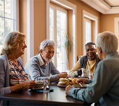 Group of older adults sitting at a table enjoying breakfast together