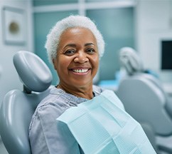 Woman with white hair sitting in dental chair awaiting exam