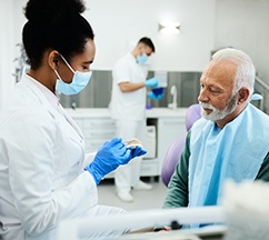 A dentist explaining how to adjust to dentures to a patient