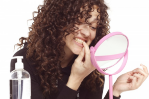 Woman staring intently at mirror and examining her teeth